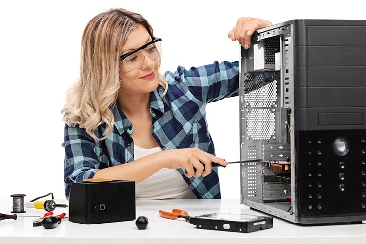 Young blond woman fixing a computer